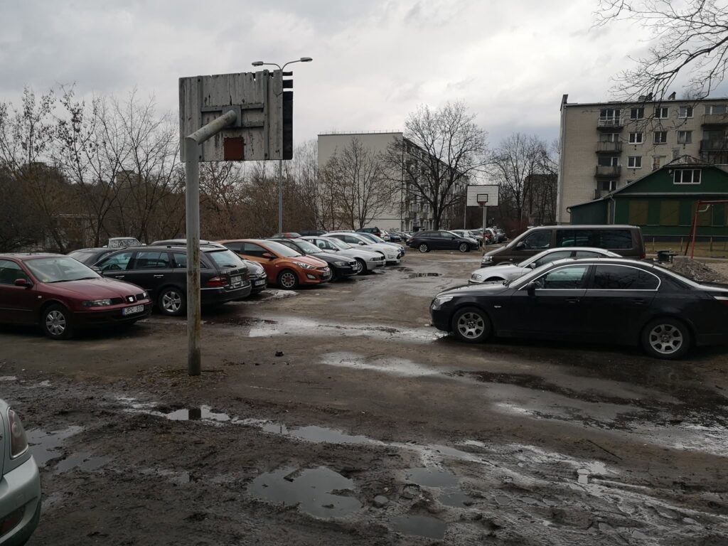 Krepšinio stovas tarp automobilių, pastatytų purvinoje aikštelėje Antakalnyje